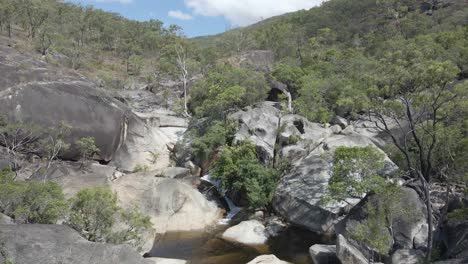 davies creek falls - stream flowing through boulders in the forest on a sunny day in summer - far north queensland, australia