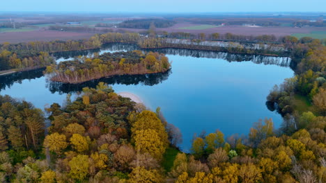 serene lake in the netherlands. a tranquil lake surrounded by autumn trees showcases the beauty of nature in the netherlands during a clear day