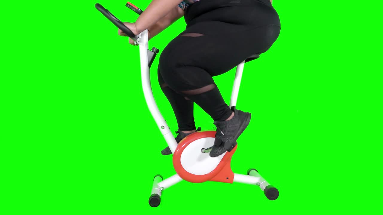 Overweight woman riding exercise bike