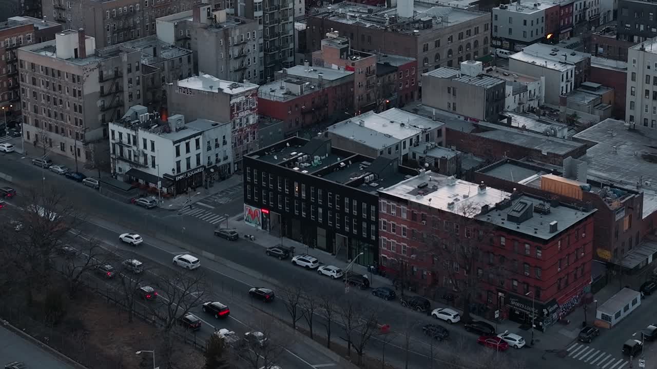 Traffic moves along streets in New York City at dusk near buildings