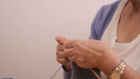 senior woman knitting a wool