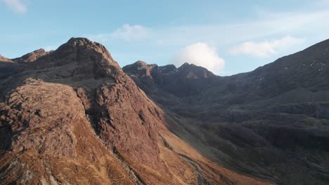 drone lifting shot of the cuillin mountains illuminated by sunlight at isle of skye in scotland