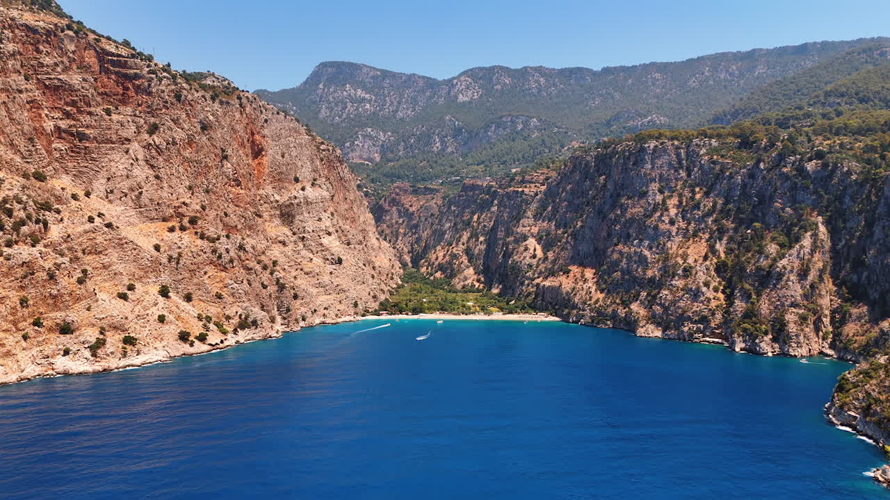 Serene coastal view of a secluded beach. A peaceful beach nestled between rugged cliffs under a clear blue sky