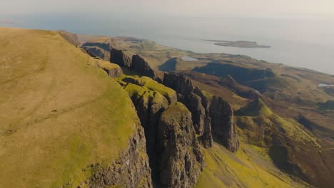 aerial drone footage of the dramatic mountain landscapes on the isle of skye, scotland. sweeping panoramic views of majestic peaks, green valleys, and wild nature. quiraing walk