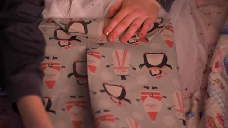 close-up of little girl wrapping birthday presents or christmas gift at home