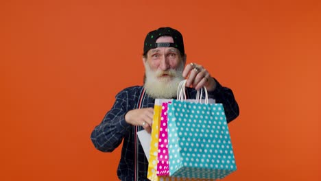 Elderly-bearded-man-showing-Sale-inscription-banner-text,-advertising-discounts,-low-holidays-prices