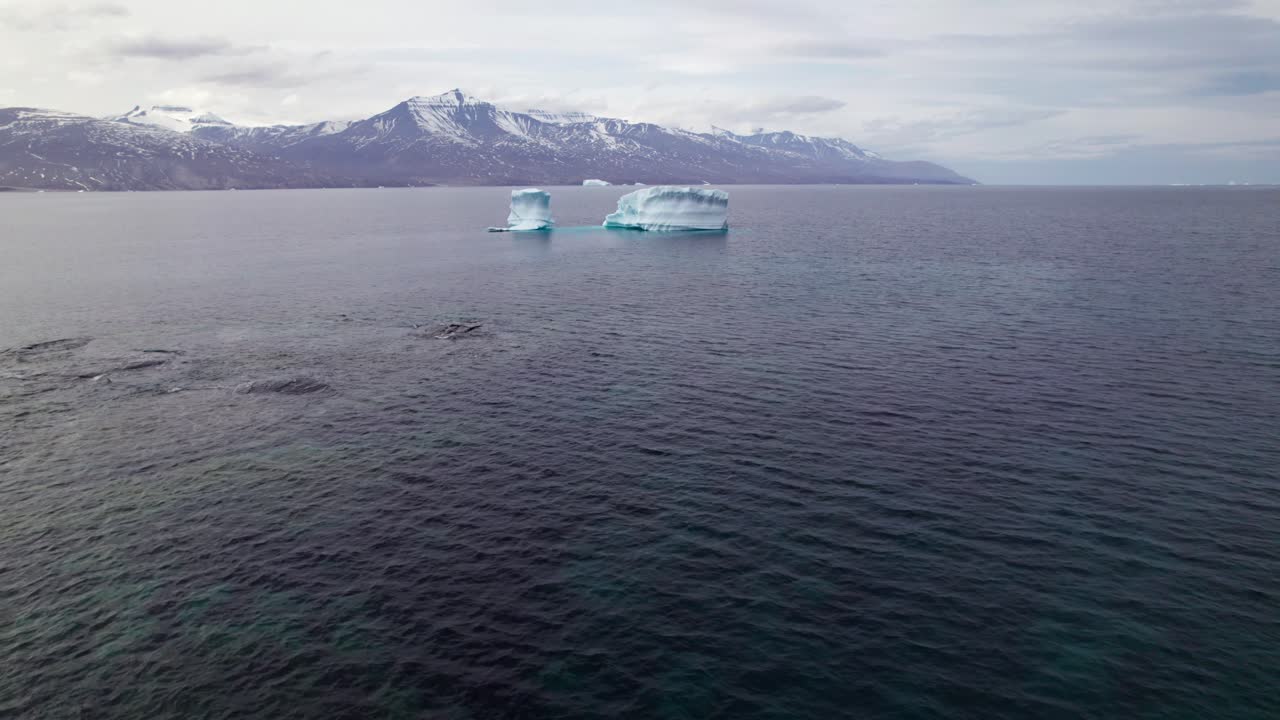 Experience profound solitude in the Greenlandic North. This footage captures the untouched, remote wilderness of Uummannaq's vast and quiet fjord system with a solo stranded iceberg
