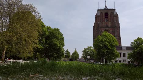 old church tower oldehove leeuwarden fast dolly shot in front the river ee with moored boats in the park