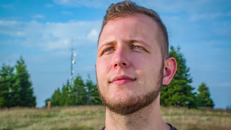 Portrait-zoom-out-blond-male-blue-eyes-beard,-looking-out-smiling