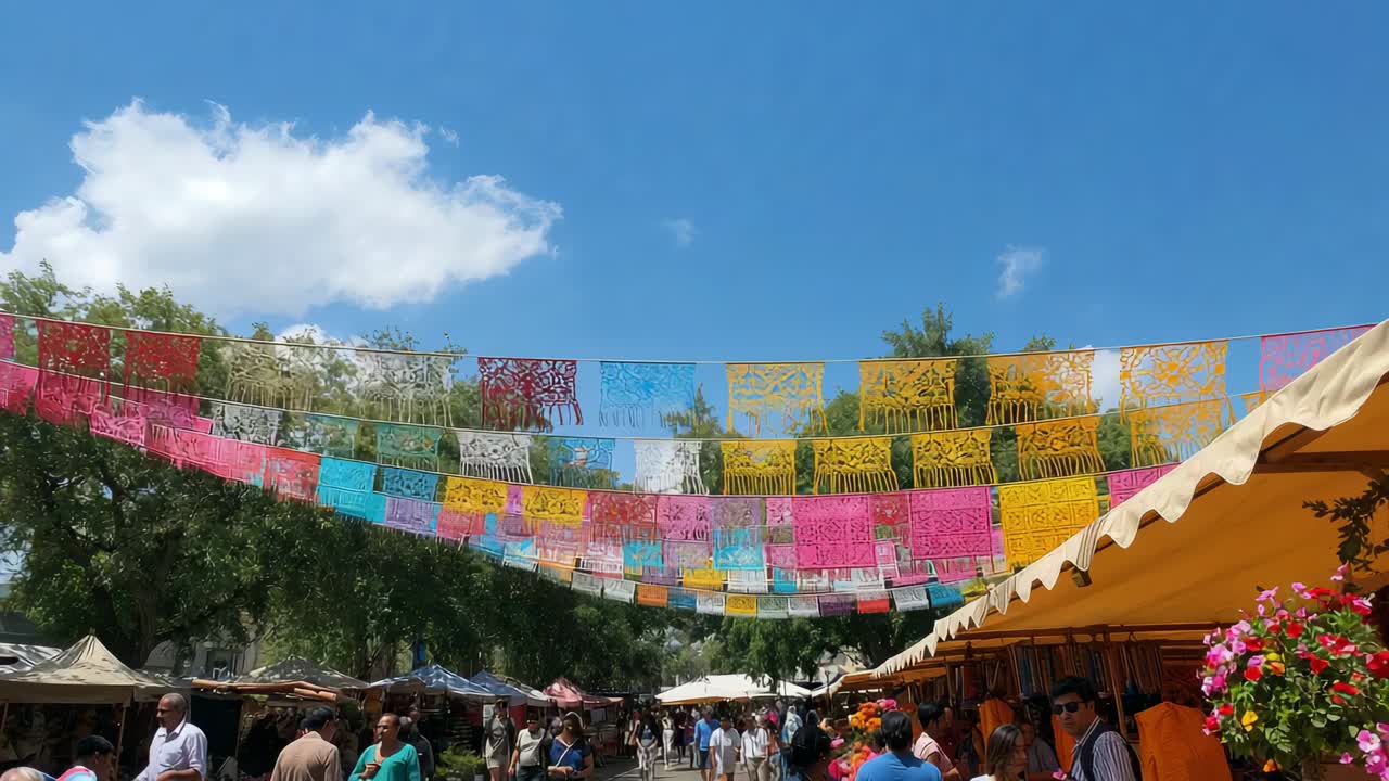 Fluttering papel picado banners in breeze above open-air market, crowd wearing hats browsing stalls