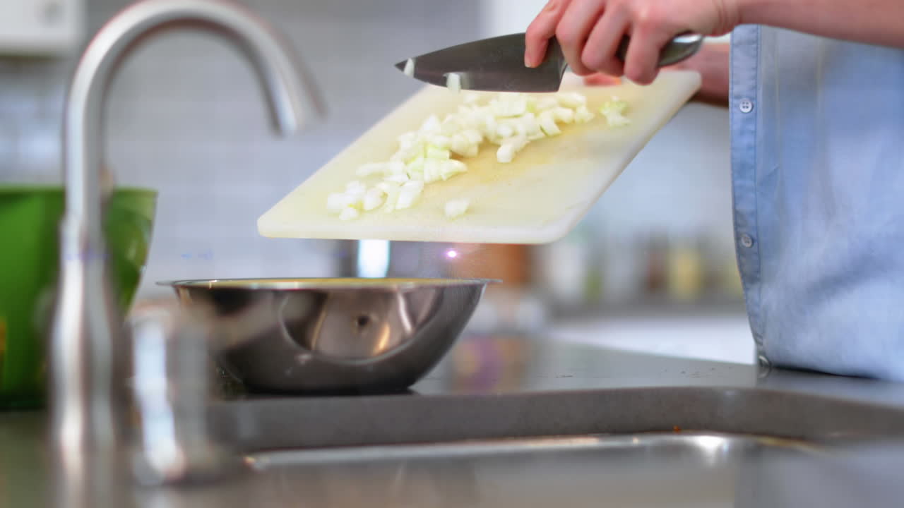 Animazione di luce sul busto di un uomo che cucina usando un coltello e un tagliere in cucina.