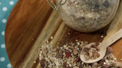 frasco de granola casera y muesli con cuchara en tabla de madera 4k