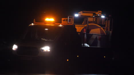 Slow-motion-shot-of-a-UK-roadworks-van-revealed-from-behind-passing-traffic-at-night