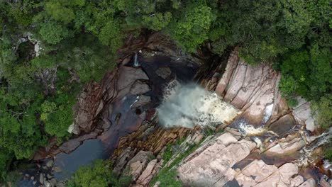 Aerial-drone-descending-and-rotating-top-down-shot-of-the-incredible-Mosquito-Falls-surrounded-by-tropical-jungle-and-cliffs-in-the-Chapada-Diamantina-National-Park-in-Northeastern-Brazil