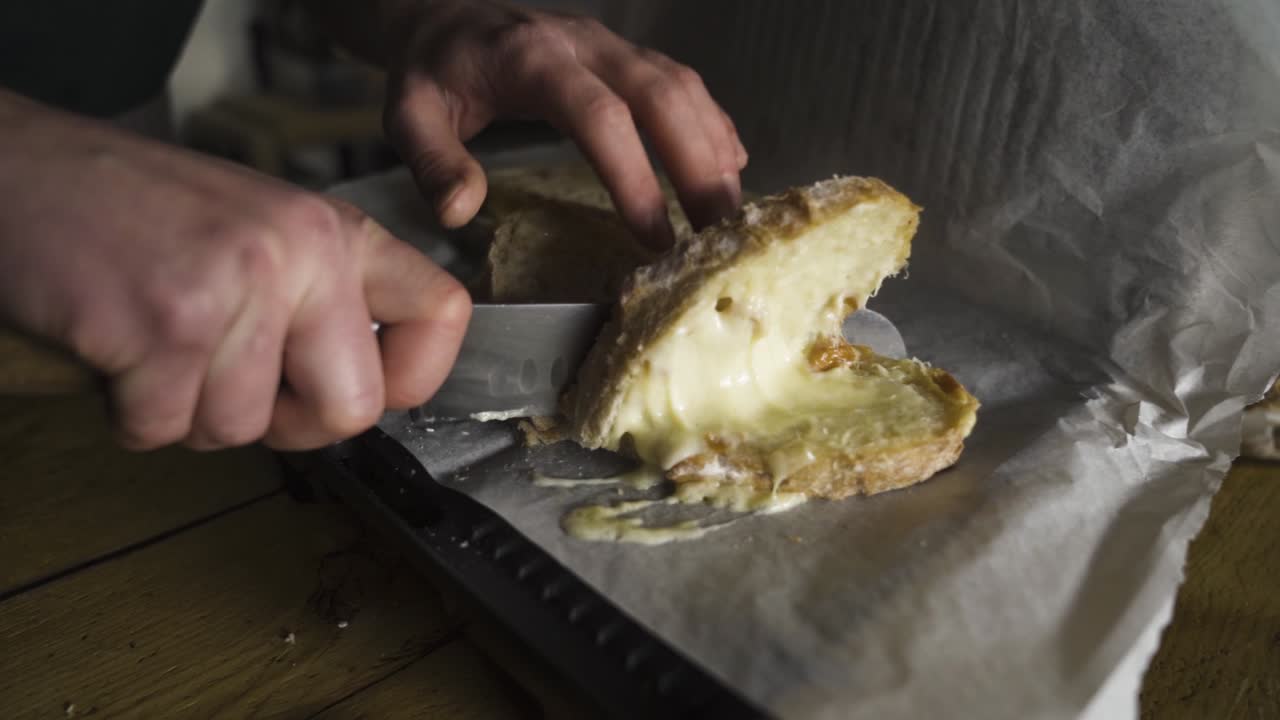 Un uomo taglia un toast caldo e filante in una caffetteria. Un barista affetta il pane. Breve ripresa in slow motion con a7 III.