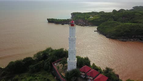 baron beach lighthouse on hilltop protecting ships from dangerous rocks in indonesia