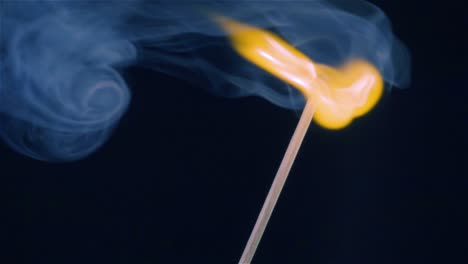 burning match on a black background in slow motion