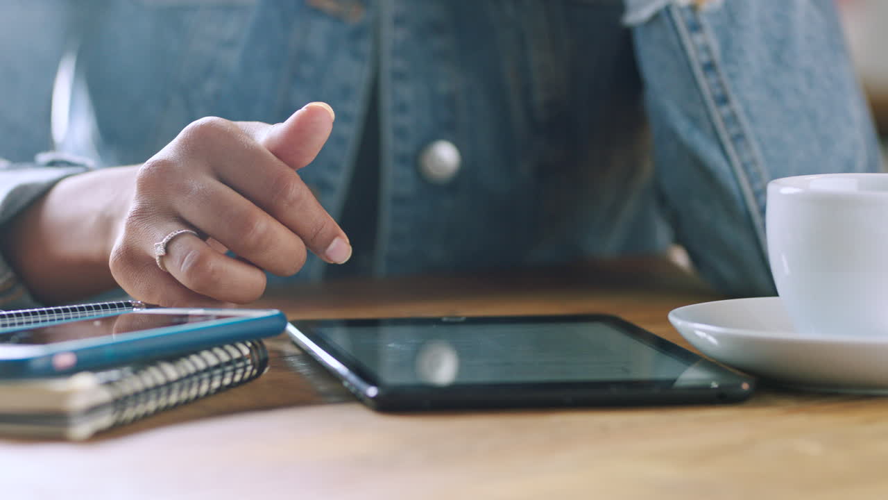 mujer trabajando en una tableta en un café