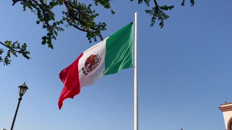 the national mexican flag waving in the wind in san jose del cabo, mexico, slow motion