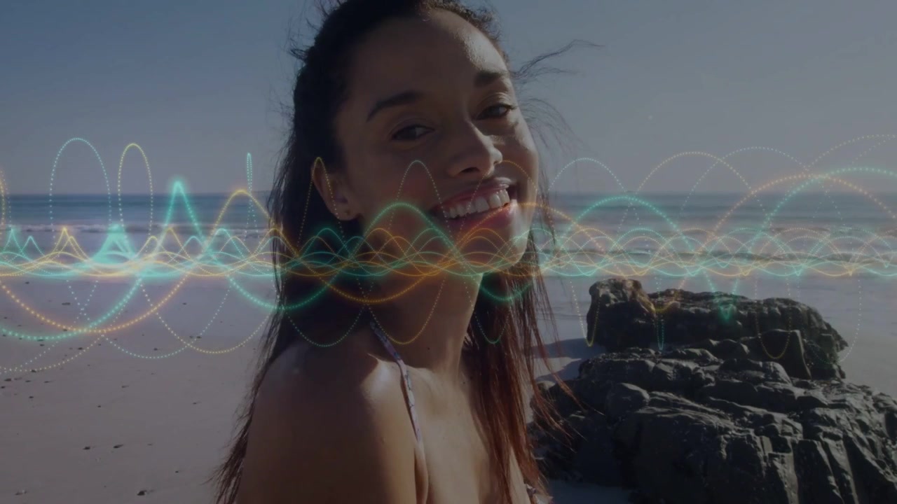 Donna che si gira verso la telecamera dopo la pulsazione di una forma d'onda, sincronizzando il movimento delle labbra, ridendo in spiaggia per marketing.
