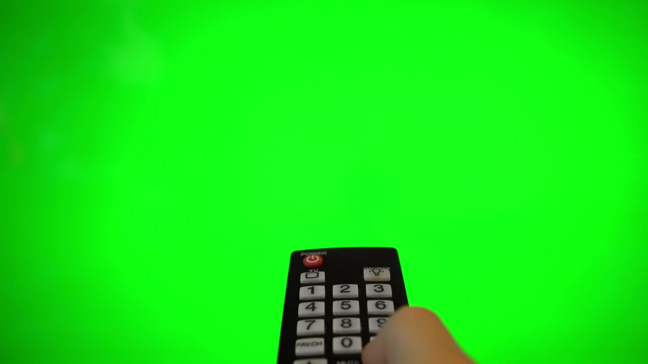 tv 화면을 가리키는 리모컨을 가진 남성 손. 녹색 크로마 키.