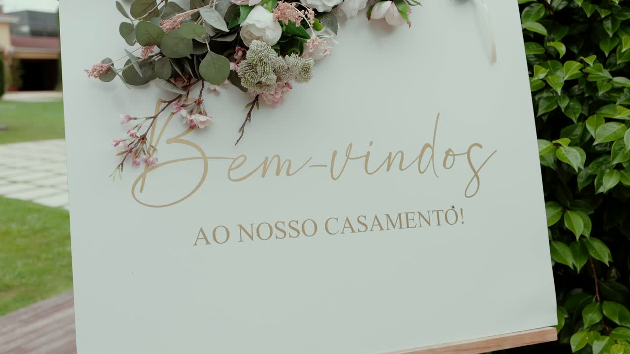 elegant welcome sign with floral decor saying bem vindos ao nosso casamento in portuguese