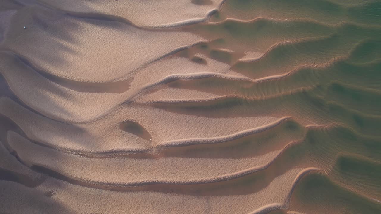 enormes crestas de dunas de arena parcialmente sumergidas en agua