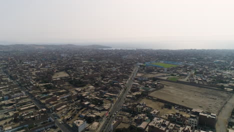 drone shot rotating over the huacho city, daytime haze in peru, south america