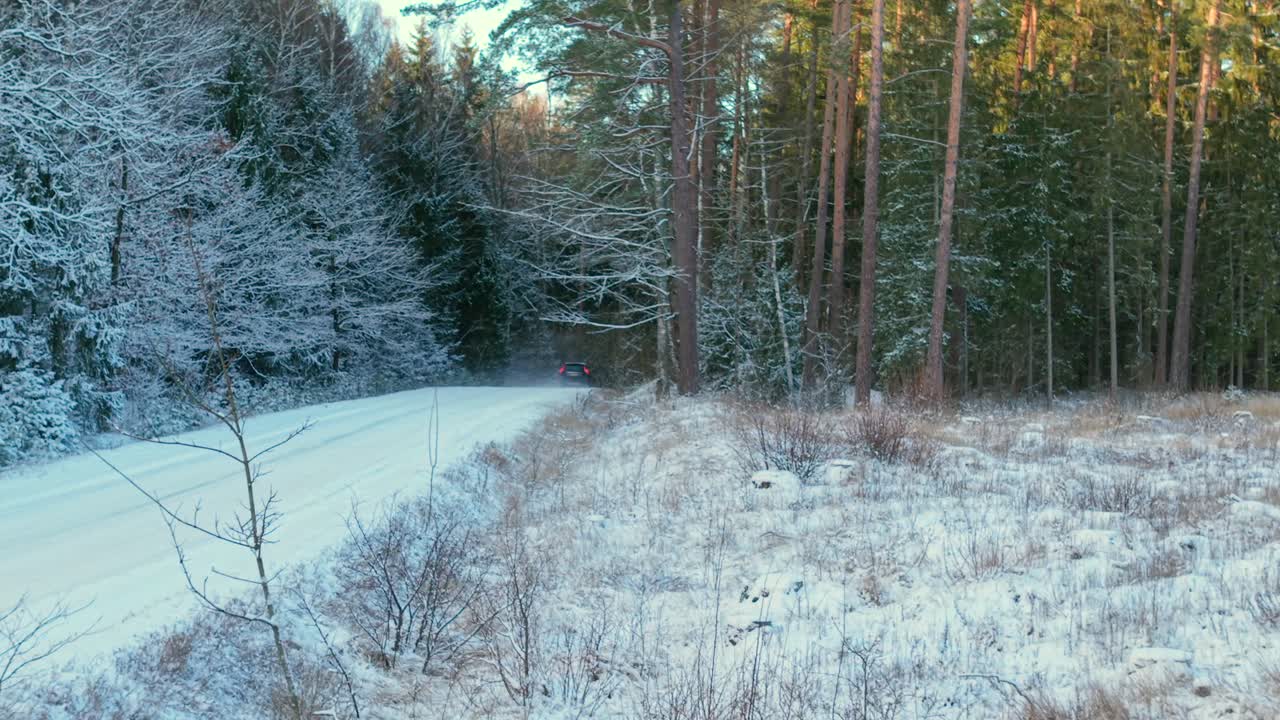 Aerial vehicle tracking view, countryside track, woodland snowy weather