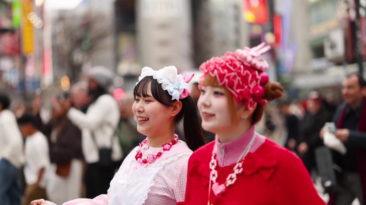 Due giovani donne in stile Harajuku che camminano per una strada trafficata di Tokyo
