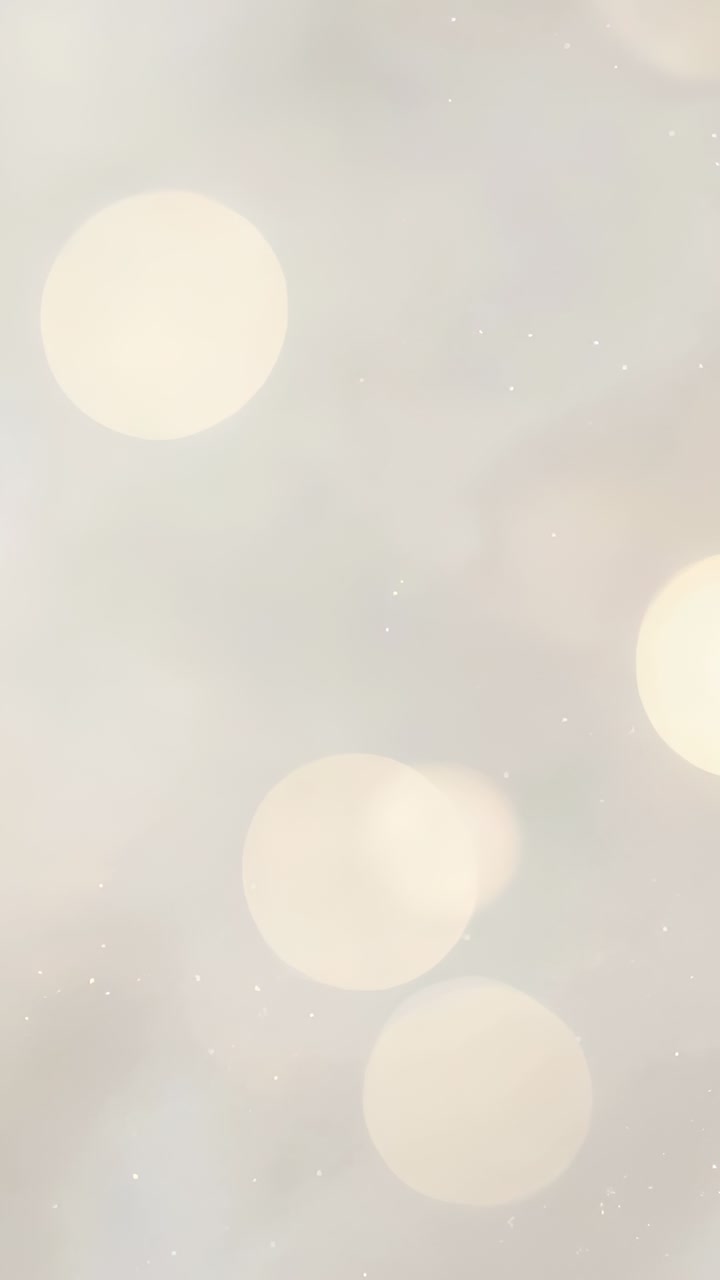 Vertical video: Shifting camera focusing on hanging bulbs at ceiling, revealing warm circular bokeh