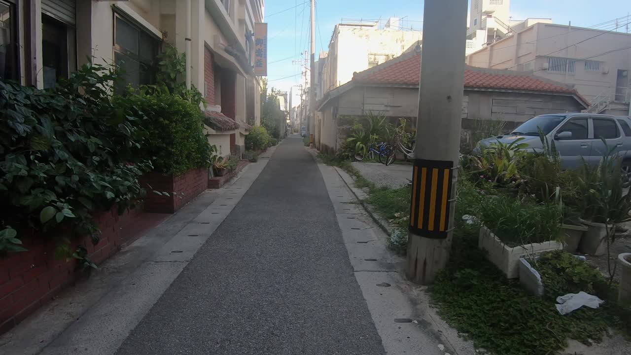 POV Walking down a residential street alley past houses and apartment buildings. Ishigaki, Okinawa, Japan. Circa September 2019
