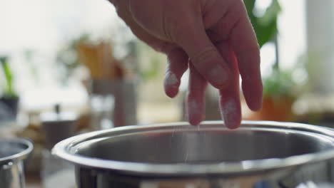adding salt to water in pot