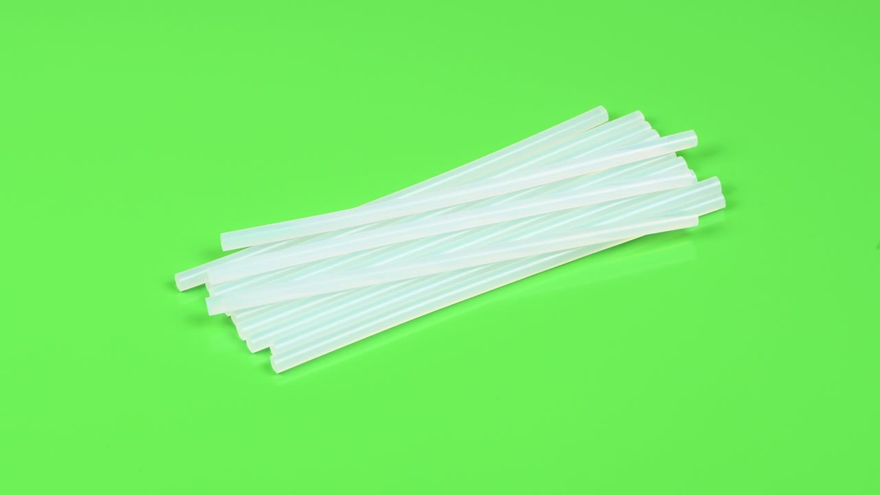 접착제 총 실리콘 스틱을 녹색으로 분리합니다. 측면 뷰. 루프 모션. 회전 360.