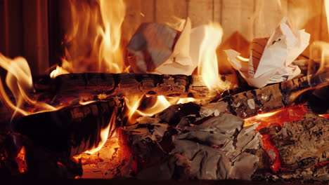 crumpled pieces of paper documents are burned in a fireplace