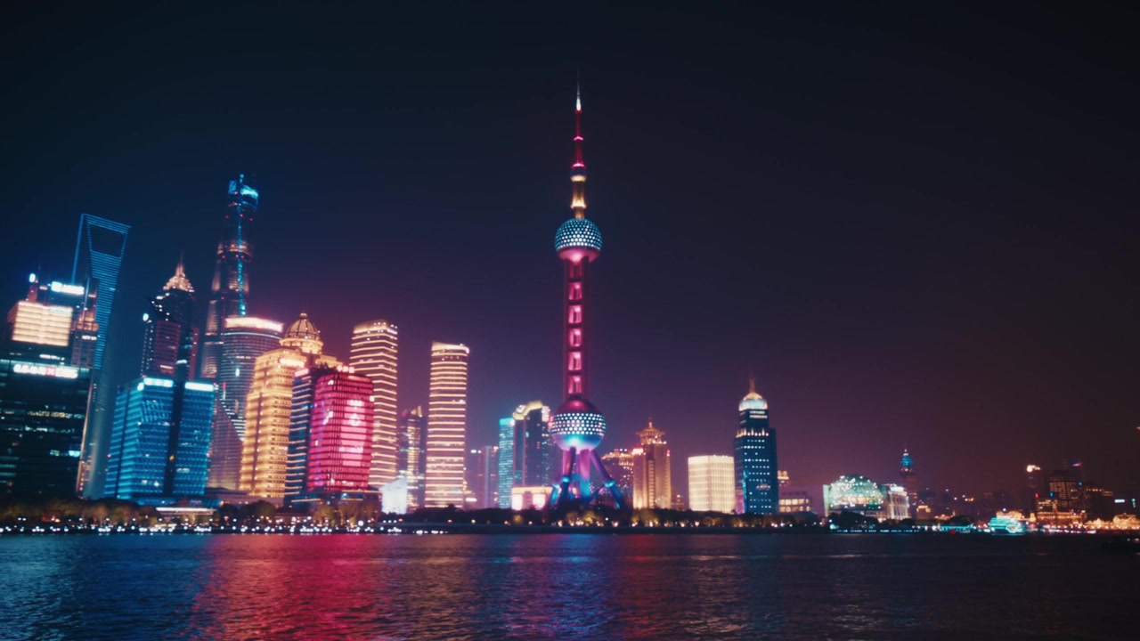 Veduta notturna dello skyline di Pudong Lujiazui dalla passeggiata del Bund, Shanghai. La Oriental Pearl Tower, lo Shanghai World Financial Center e la Jin Mao Tower sono tutte visibili attraverso il fiume Huangpu