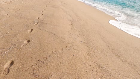 walking,walking-in-the-sand,calm-mediterranean-sea,barcelona-spain-,-footprints-in-the-sand