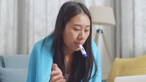 woman checking her temperature at home