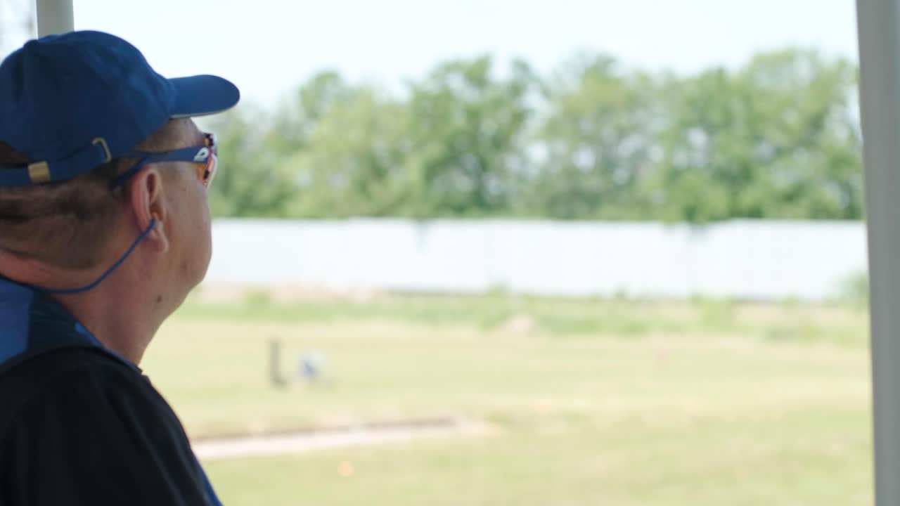 un deportista dispara con una escopeta de doble cañón, un campo deportivo para una prueba de tiro está disparando a un esquete volador