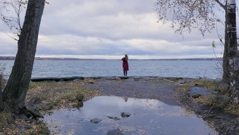 woman in red coat by the lake in autumn