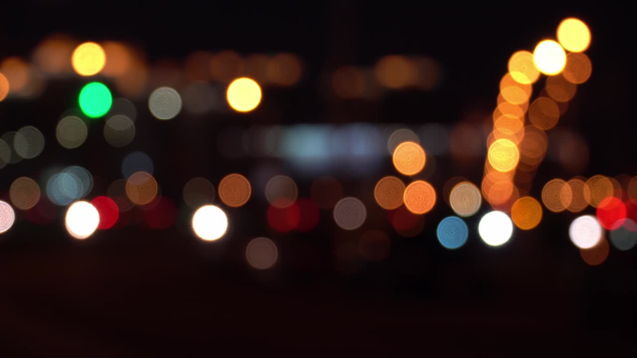 hermoso bokeh brillante en el fondo oscuro borroso por la noche. redondo colorido bokeh brilla de las luces de los coches en el atasco de tráfico en la calle de la ciudad. concepto abstracto. refleja el estilo de vida solitario de la ciudad capital.