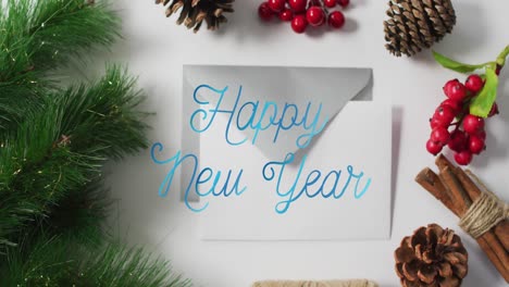 animación de banner de texto de feliz año nuevo sobre decoraciones de navidad y sobre sobre superficie gris.