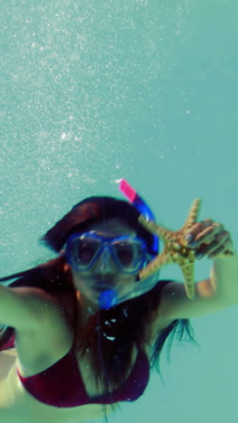 pretty brunette diving into swimming pool wearing snorkel