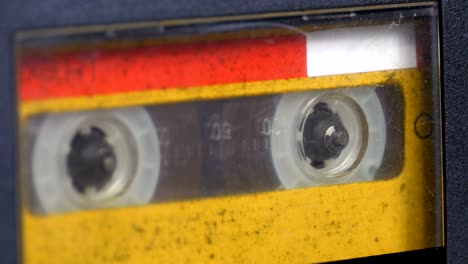 the vintage yellow audio cassette in the tape recorder rotates