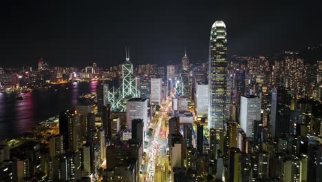 a stunning view of a bustling city skyline at night, featuring bright lights from skyscrapers and reflections on the nearby water. the vibrant energy showcases a lively urban atmosphere.