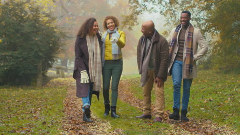 portrait of smiling multi-generation family walking through autumn countryside together