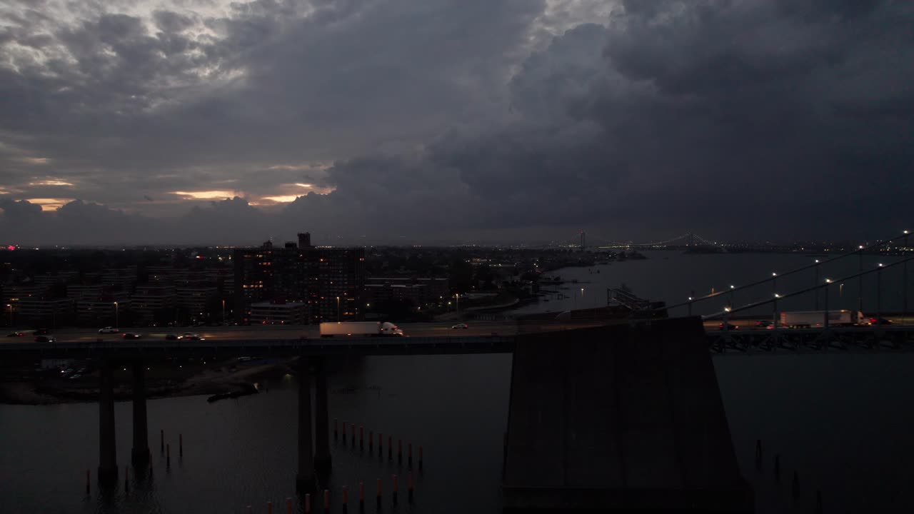 Night traffic on a New York City bridge, side-view aerial shot, 4K