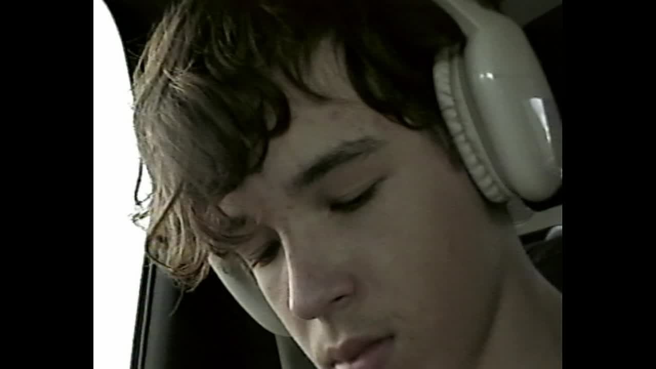 Teenager with headphones inside a car