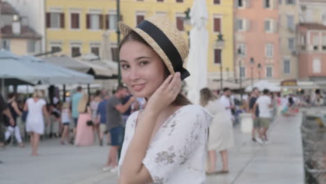 woman wearing a straw hat in a european city square