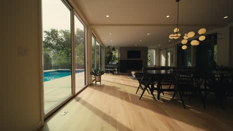 interior living space of a luxury home lined with large sliding doors letting in natural sunlight to showcase a dining area, couch, and a piano